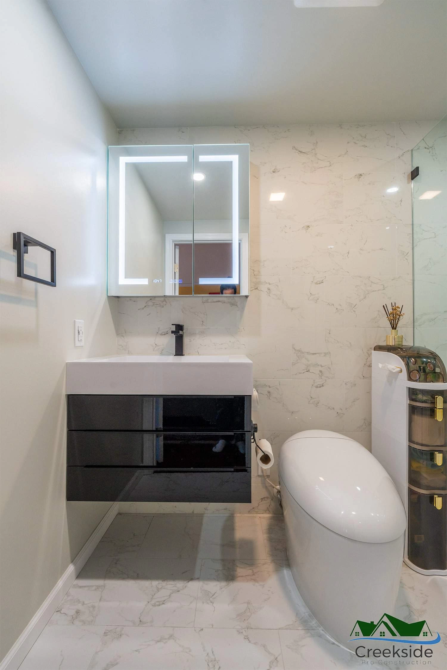 A bathroom with a toilet, sink and mirror in Contra Costa County, CA.
