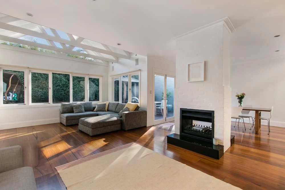 A living room with a fireplace and wooden floors in Contra Costa County, CA.